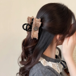 Dettaglio della molletta per capelli in tweed con cristallo quadrato su capelli lunghi