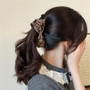 Barrette banane à nœud léopard multicouche pour femme sur une coiffure queue de cheval