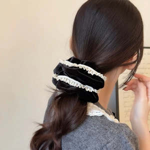 Elegant black velvet scrunchie with white lace trim for hair styling and ponytails