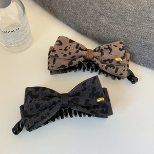 Vue détaillée des pinces à cheveux à motif léopard avec plaque métallique élégante fait main