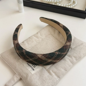 Macro shot of thick brown plaid headband showing detailed fabric texture and anti-slip lining