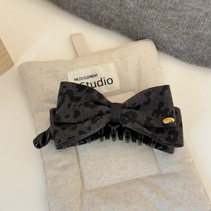 Détail de la pince à cheveux léopard avec plaque dorée Hand Made et texture jacquard