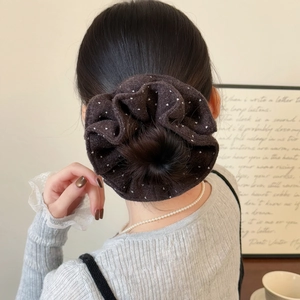 Vintage dark velvet scrunchie with white polka dots worn on a stylish low bun