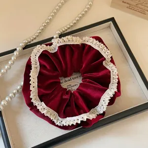 Detailed close-up of a vintage velvet hair scrunchie with lace edges on a tray