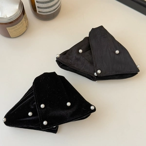Detailed view of large black velvet hair claw clips with elegant pearl embellishments