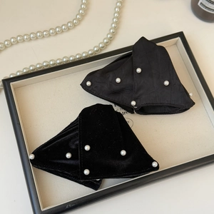 Detailed view of French vintage velvet and satin hair claws with white pearl accents