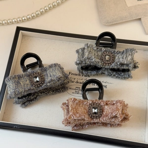 Dettaglio di fermagli per capelli in tweed con fiocchi e diamanti rettangolari in tre colori
