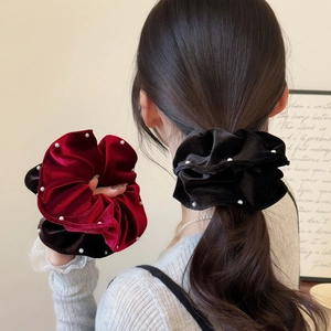Elegant velvet hair scrunchies with white pearls shown in black and burgundy on a ponytail
