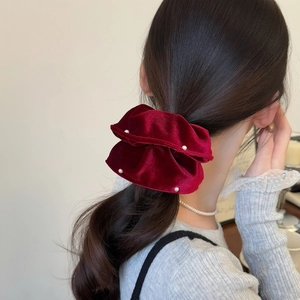 Detail of dark red velvet scrunchie with pearls styled in a low ponytail for women