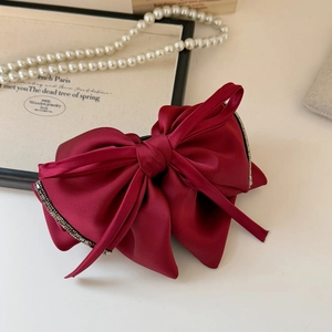 Detailed macro view of the wine red layered satin bow hair clip with rhinestone accents