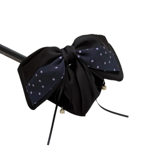 Vintage retro polka dot bow hair clip with black ribbons and pearl pendant on white background