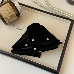 Detailed view of large black velvet hair claw clip with hand-set white pearls for women