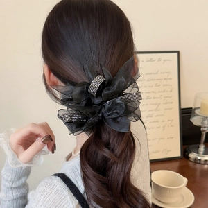 Detail of large black mesh bow hair tie with silver rhinestones on a ponytail