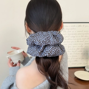 Floral oversized scrunchie in navy blue with light blue flower print on low ponytail