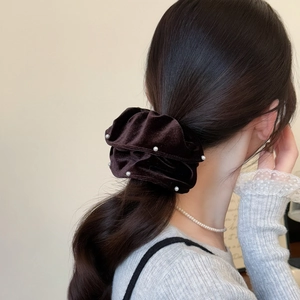 Brown velvet scrunchie with pearls styled on a low ponytail for a classy look