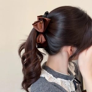 Elegant dark brown velvet double bow banana clip hair accessory worn on a low ponytail