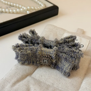 Dettaglio del fermaglio per capelli in tweed con fibbia vintage e strass grigio