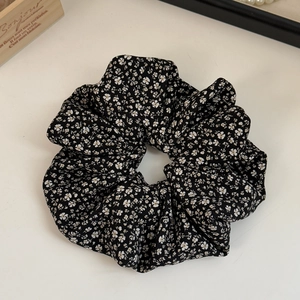 Detail of floral scrunchie in black chiffon fabric with delicate yellow and white blooms