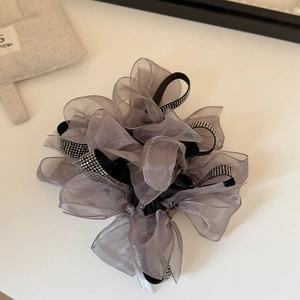 Detail of grey mesh scrunchie featuring rhinestone ribbon and layered organza fabric
