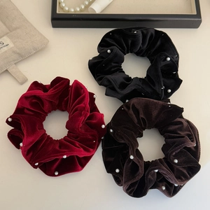 Set of three premium velvet scrunchies with elegant white pearls in black, red, and brown.