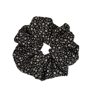 Elegant black scrunchie with white floral pattern for stylish ponytails and buns