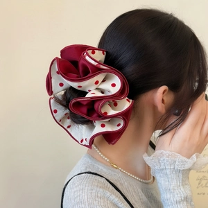 Retro red polka dot oversized hair scrunchie shown in an elegant high bun style