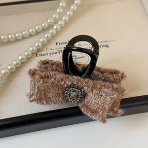 Dettaglio del fermaglio per capelli in tweed con cristallo e montatura in metallo retrò