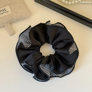 Detail view of large checkered scrunchies with elegant double-layer ruffled fabric texture
