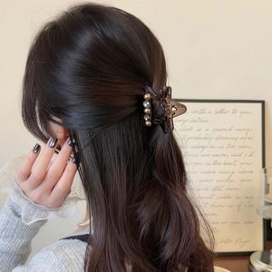 Brown star hair claw clip for half-up hairstyle on model in minimal aesthetic setting