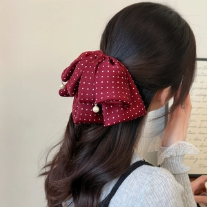 Eleganter weinroter Haclip mit Polka Dots und Perlenanhängern für langes gewelltes Haar
