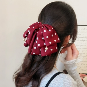 Eleganter roter Haarklammer mit Polka Dots und Perlenanhängern am Modell getragen