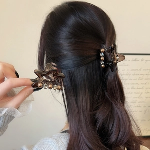 Elegant star-shaped hair claw clip with pearls and rhinestones in dark amber finish