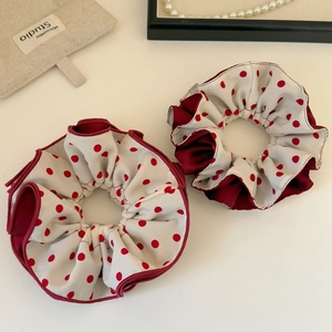 Vintage red polka dot scrunchies in cream satin with dark red fabric trim on neutral base