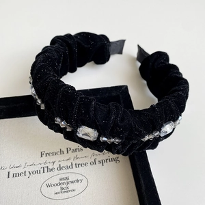 Macro view of black velvet headband with sparkling crystals and grey bead details