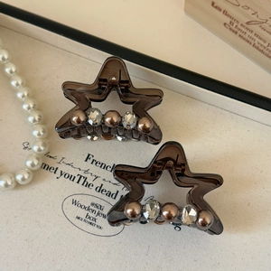 Detailed macro view of star-shaped hair clips with brown beads and sparkling rhinestones