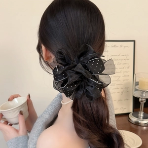 Elegant black polka dot scrunchie with layered mesh bow on ponytail hairstyle