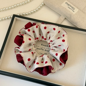 Detail of red polka dot hair scrunchie with layered burgundy satin and beige fabric