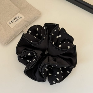 Detailed macro view of large French polka dot hair scrunchie with layered black fabric folds