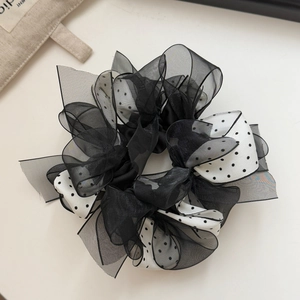 Detail view of double-layer polka dot mesh scrunchie with organza texture and retro design