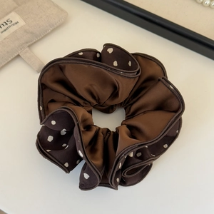 Close-up of brown polka dot oversized hair scrunchie with soft satin fabric texture