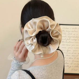 Elegant champagne gold satin scrunchie with pearl accent for chic bun hairstyle