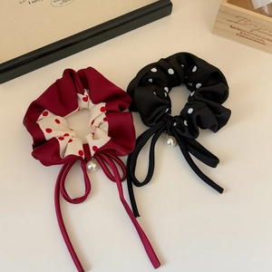 Close-up of polka dot scrunchies with ribbons and pearl charms in elegant display