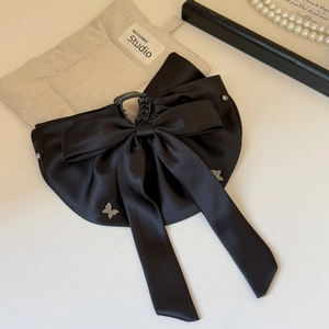 Close-up of black satin bow hair claw with elegant crystal butterfly embellishments