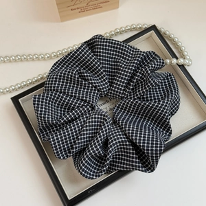 Elegant houndstooth pattern large scrunchie displayed with vintage pearls and decor