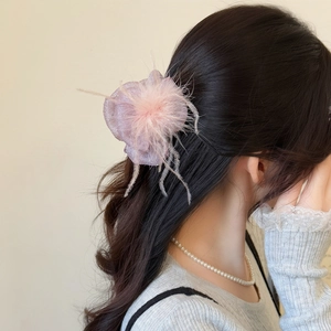 Elegant pink feather hair claw clip with shimmer mesh fabric on a soft knit model