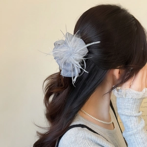 Elegant grey feather and mesh hair claw clip shown on a model for a chic hairstyle