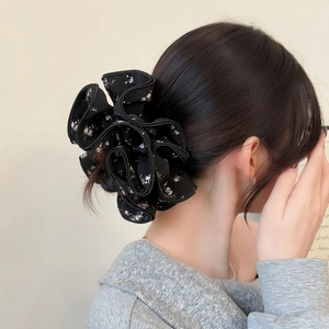 Elegant floral print fabric scrunchie in black and white worn on a ponytail