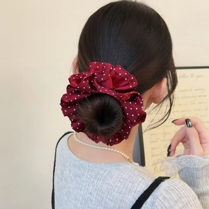 Elegant deep red polka dot silk scrunchie styled in a bun for a vintage look