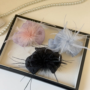 Detailed view of hair clips in pink blue and black colors with feathers and rhinestones
