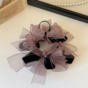 Détail d'un chouchou élégant avec ruban en velours noir et couches d'organza marron